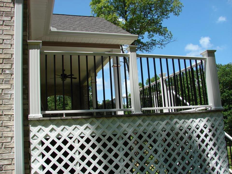 Front porch with a white deck that has black iron rails