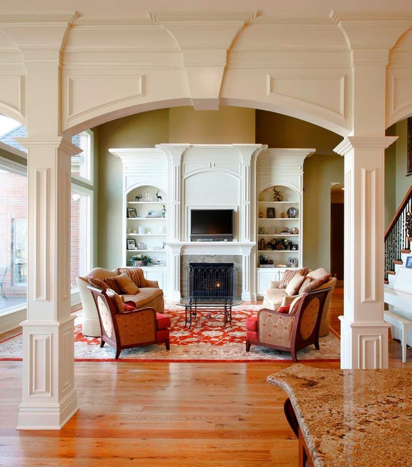 Living room with white pillars, fireplace, and seating area.