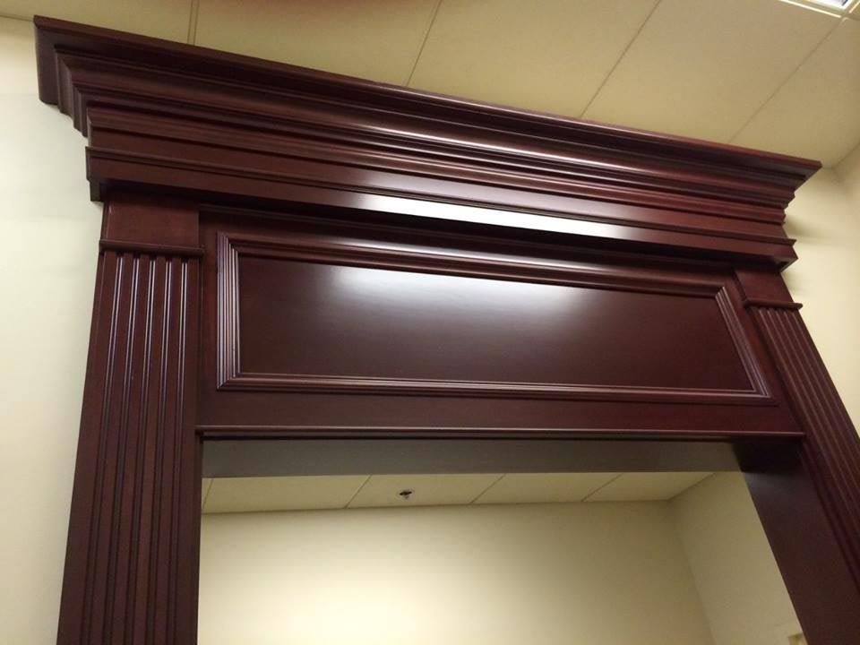 Dark wood doorway frame with decorative molding and panels.