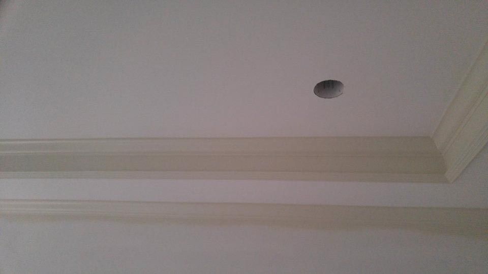 White ceiling with crown molding and a circular hole.