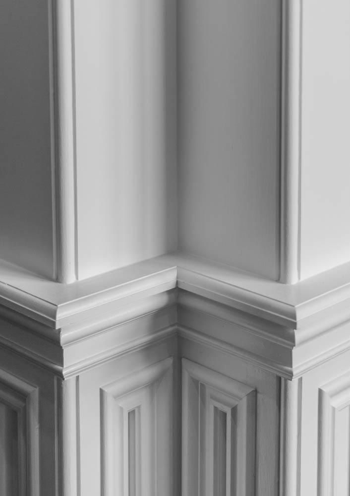 Corner of white paneled walls and trim.