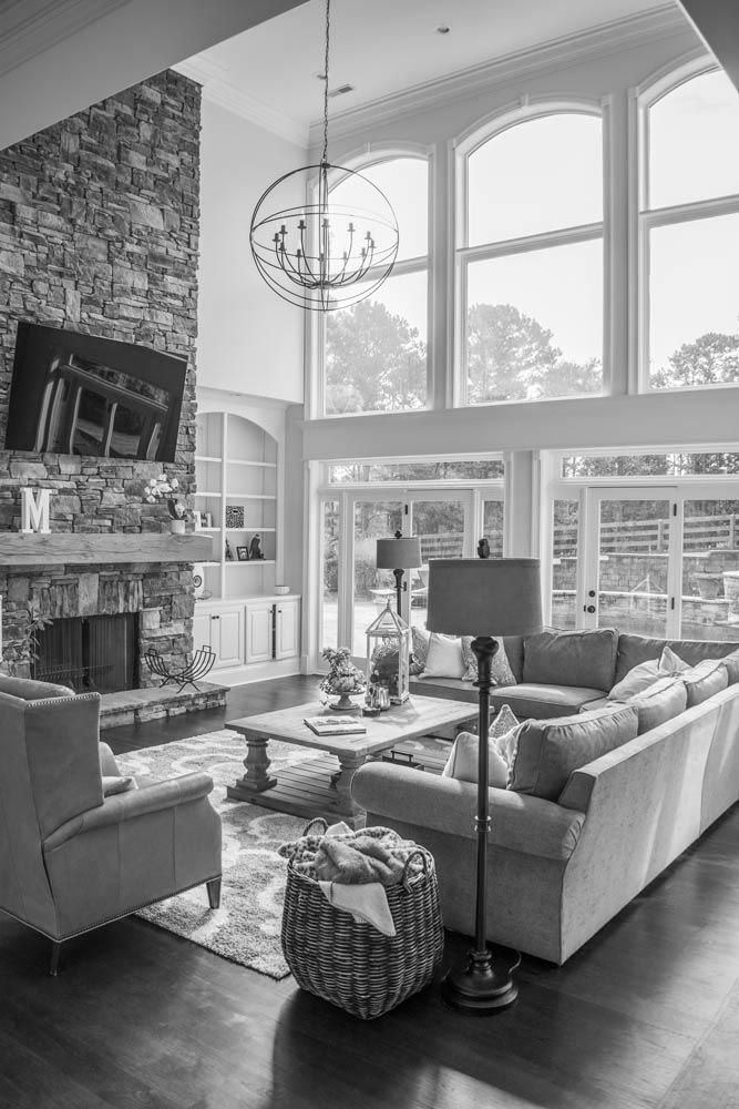 Living room with stone fireplace, large windows, and contemporary furniture.