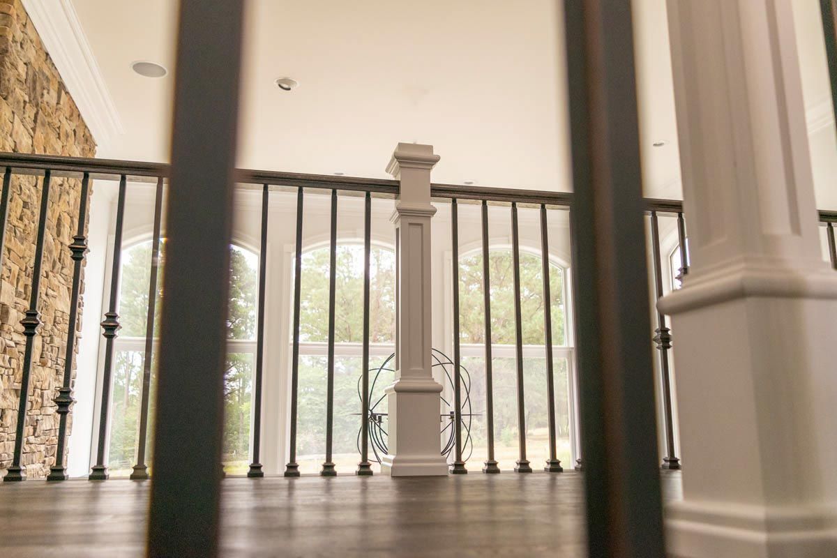 Interior view of a balcony railing, with a light-filled background.