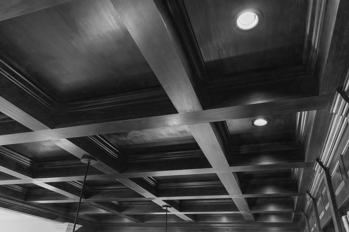 Wooden coffered ceiling with recessed lighting.