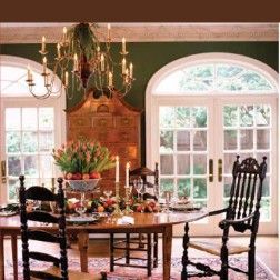 Dining room with a chandelier, wooden table, and chairs set for a meal.