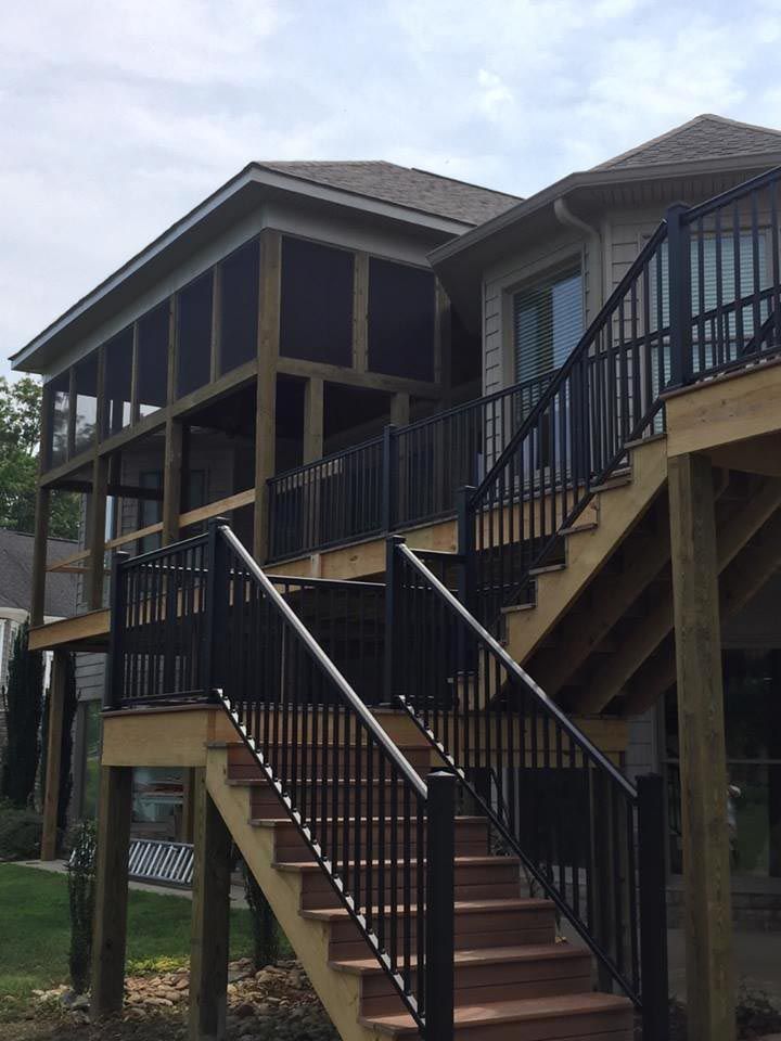Back of a home with a second level screened in porch.