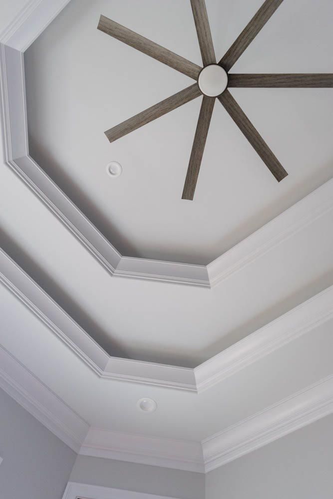 White ceiling with layered octagonal detail and a gray ceiling fan.