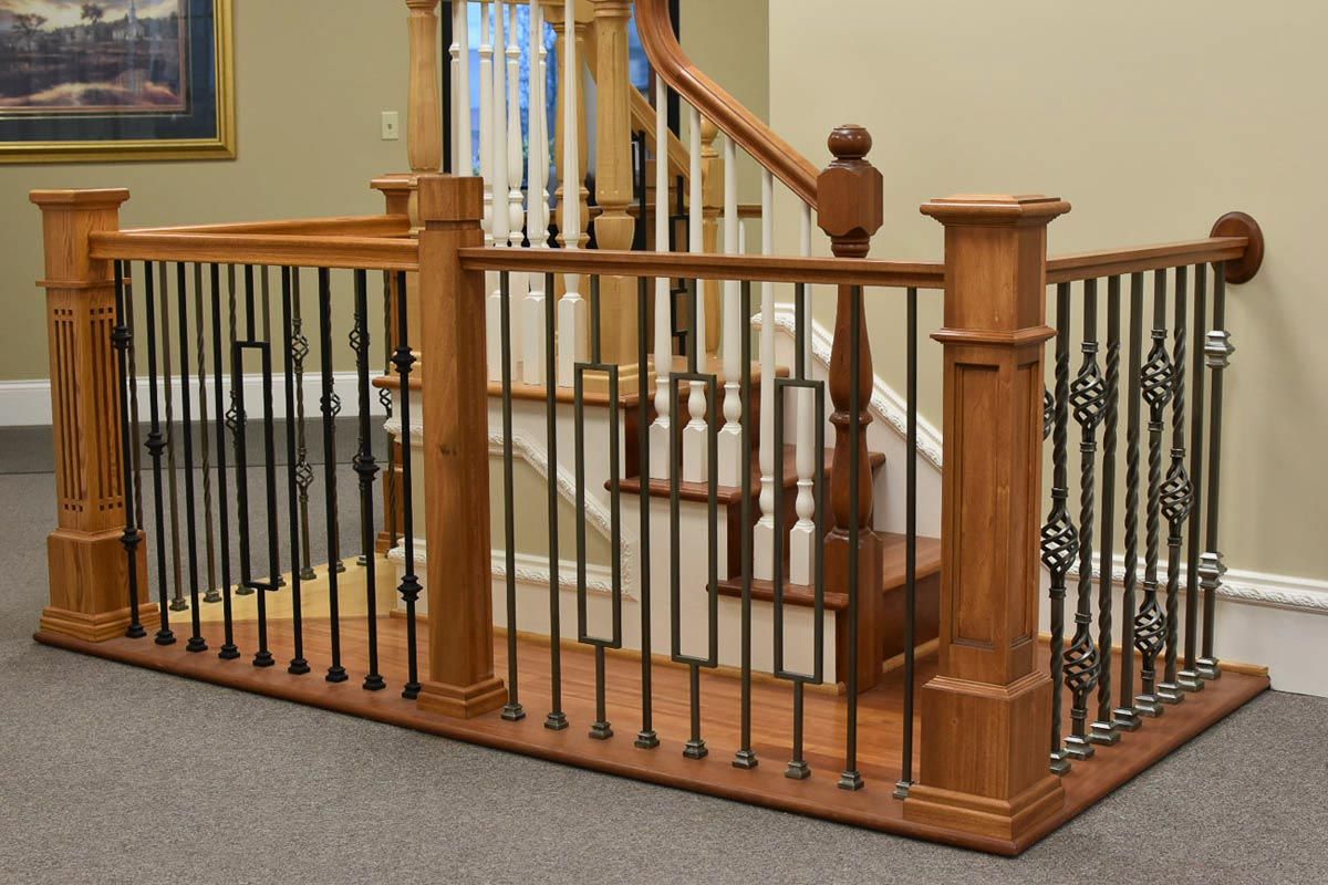 Wooden stair railing with black metal spindles.