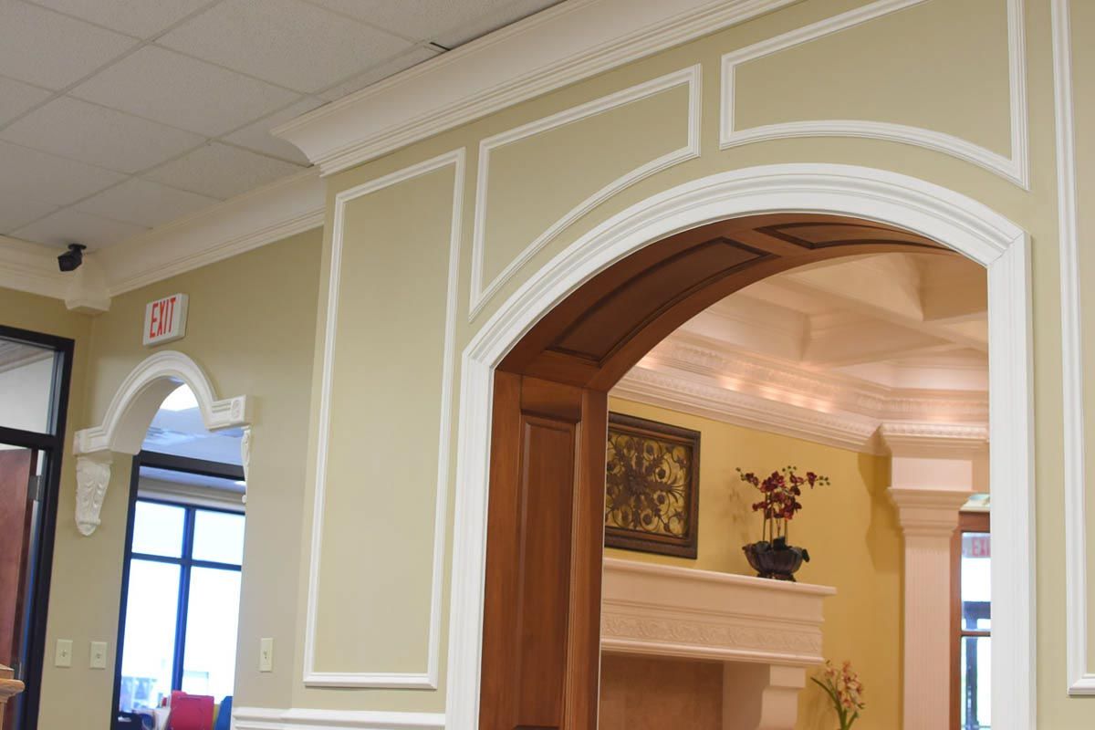 Interior with arched doorway, decorative wall panels, and cream and brown color scheme.