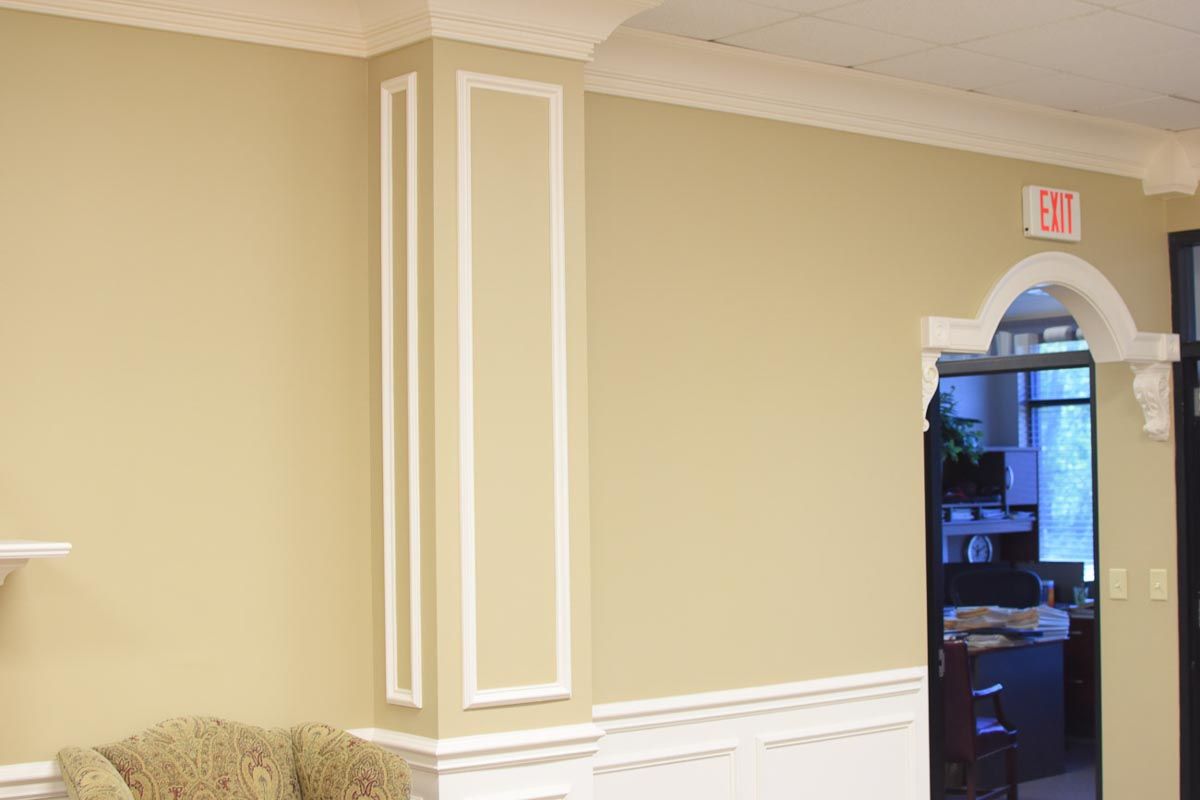 Beige office walls with white trim, arched doorway, and an