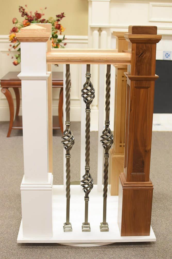 White and brown wooden stair railing with decorative metal spindles.
