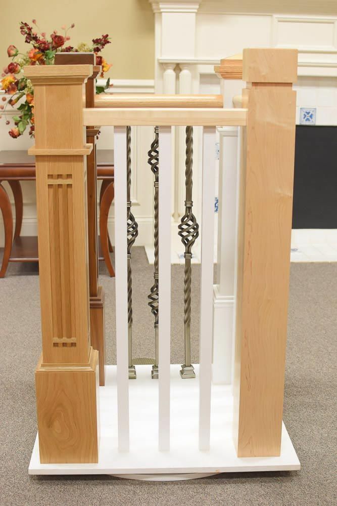 Staircase railing samples with various wood and metal designs against a neutral background.