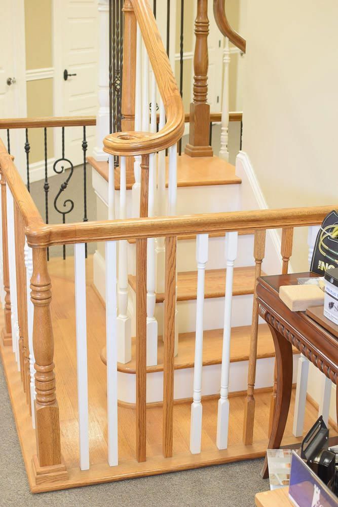 Wooden staircase with white spindles, brown railing, and a landing.