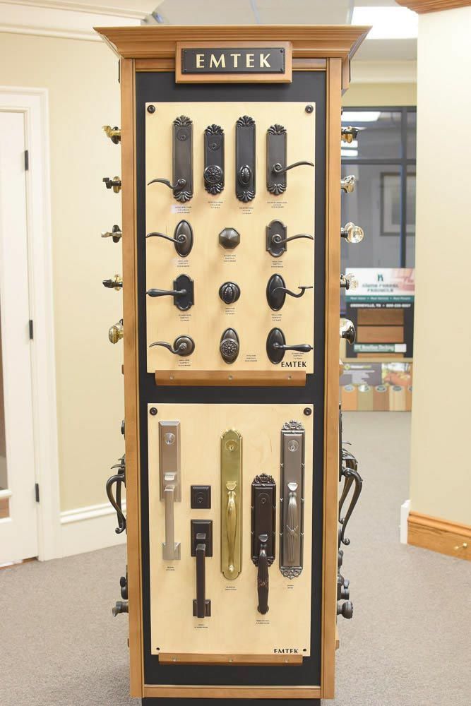 Door hardware display cabinet showcasing various Emtek door handles and levers.