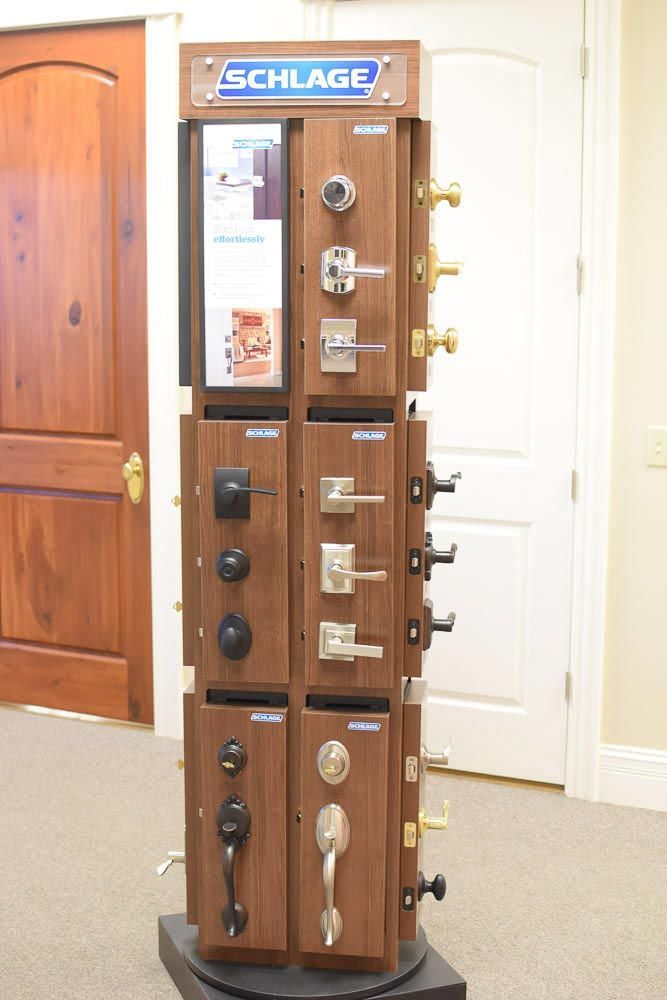 Display of Schlage door hardware options on a rotating floor stand in a showroom.