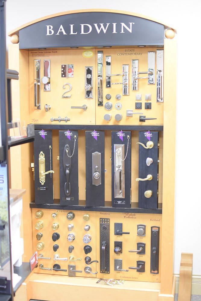 Baldwin door hardware display in a store, featuring various styles and finishes.