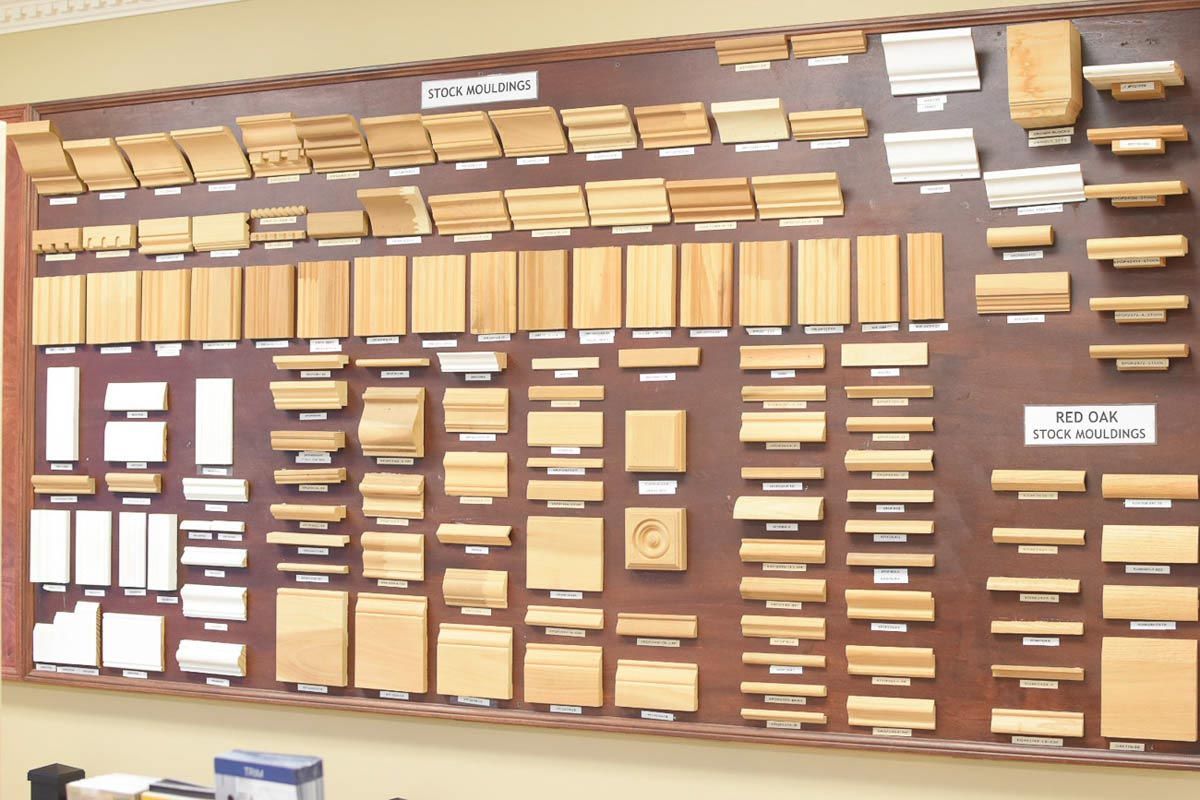 Display of various wood trim samples on a wooden board.