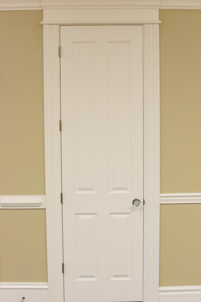 White six-panel door with white trim, set in a tan wall.