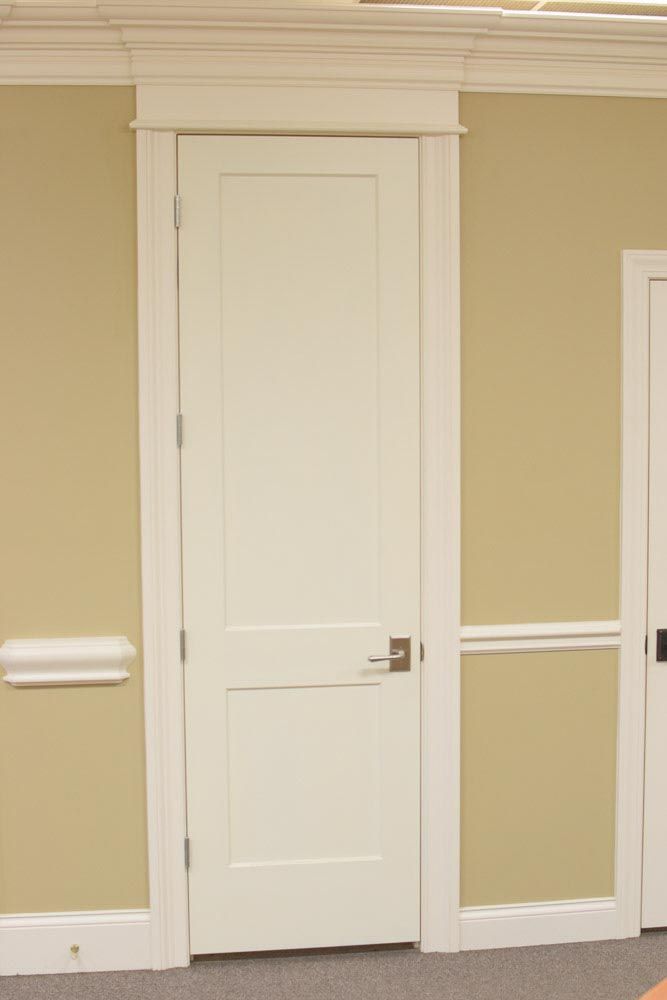 White door with white trim against tan walls.