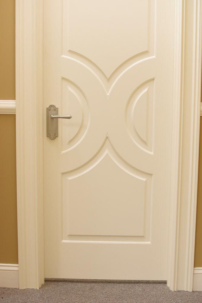 Cream-colored interior door with decorative curved paneling and silver handle.
