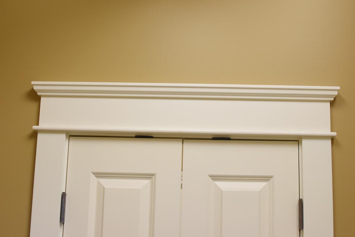 White door with ornate molding against a beige wall.