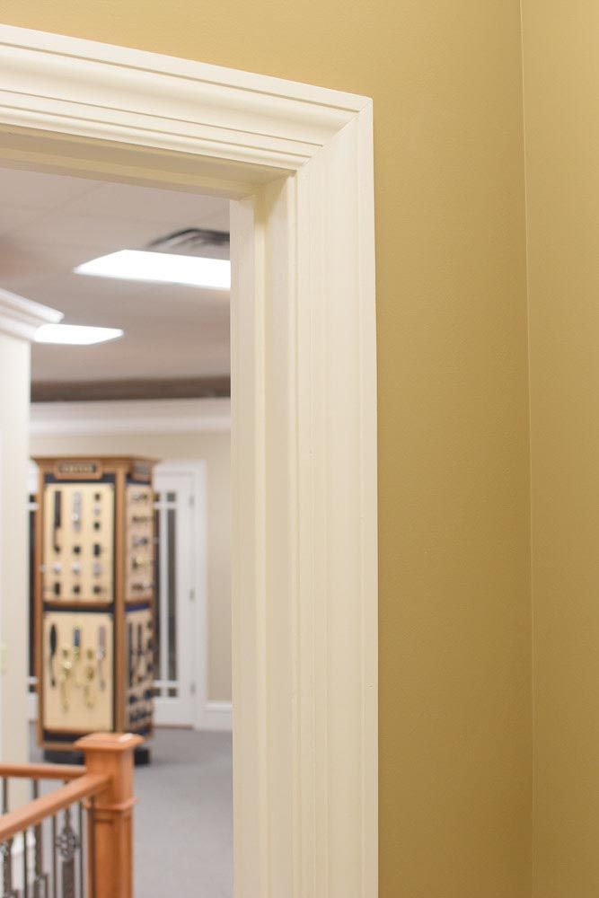 Beige doorway in a gold-colored wall. Hallway with display case and railing is visible.