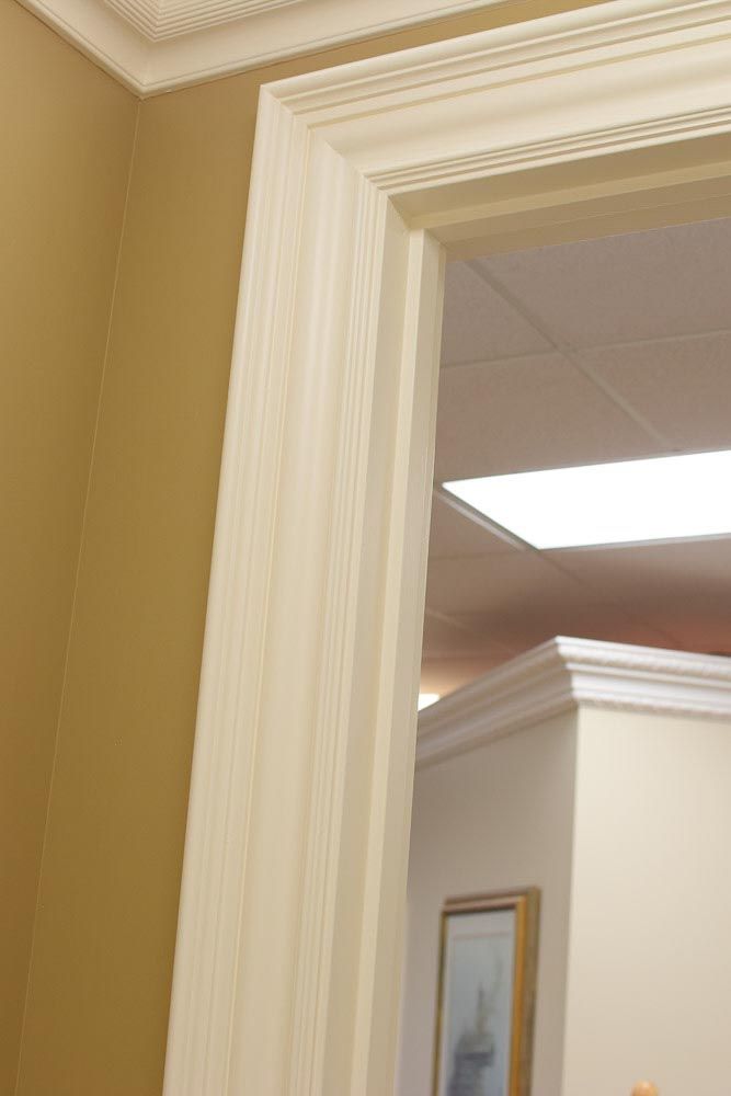 Off-white door frame with textured panels, attached to yellow wall.