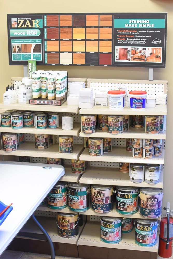 Paint display shelf with stain color samples and cans of ZAR paint.