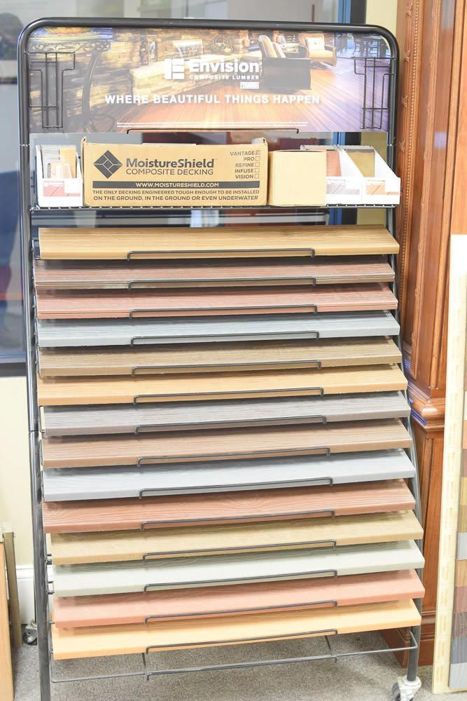 Display of various composite decking samples in multiple colors.