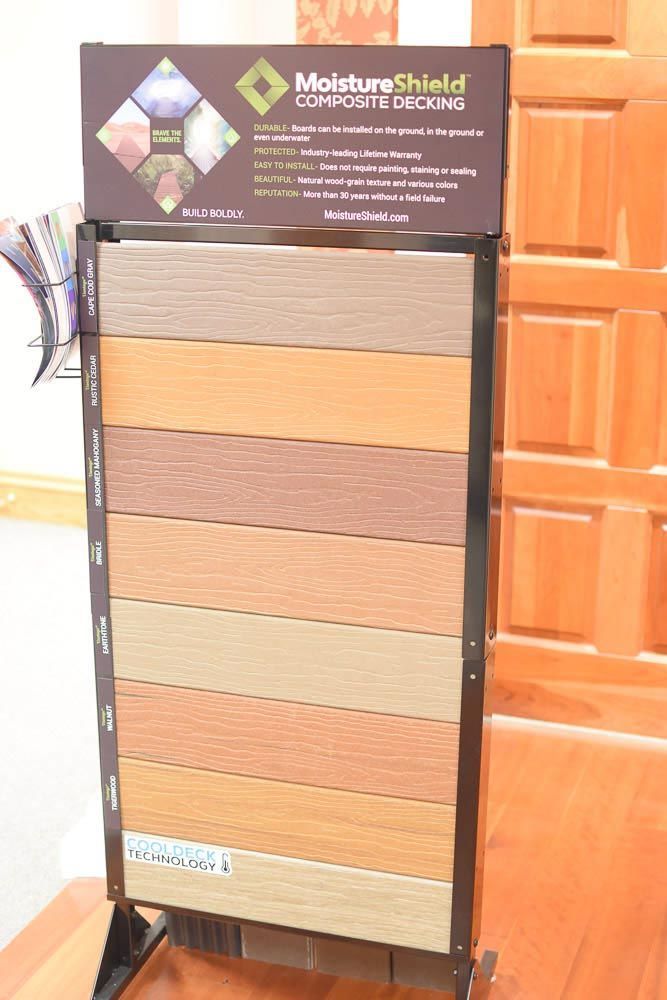 Composite decking display showcasing various wood-toned boards.