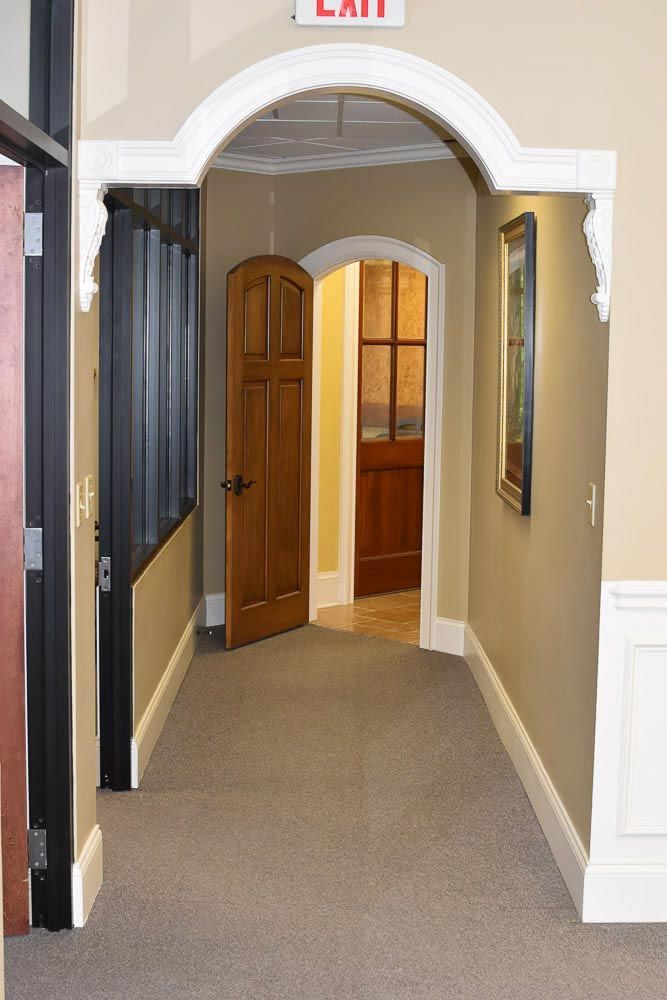 Hallway with arched doorway, two wooden doors, and