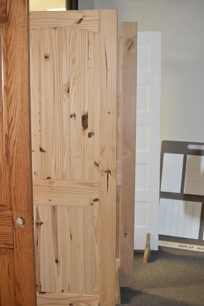 Wooden interior doors on display, varying styles and finishes.