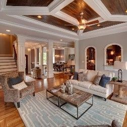 Living room with couch, chairs, wood ceiling and fireplace, soft color palette.