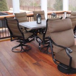 Patio table with brown chairs on a wooden deck.
