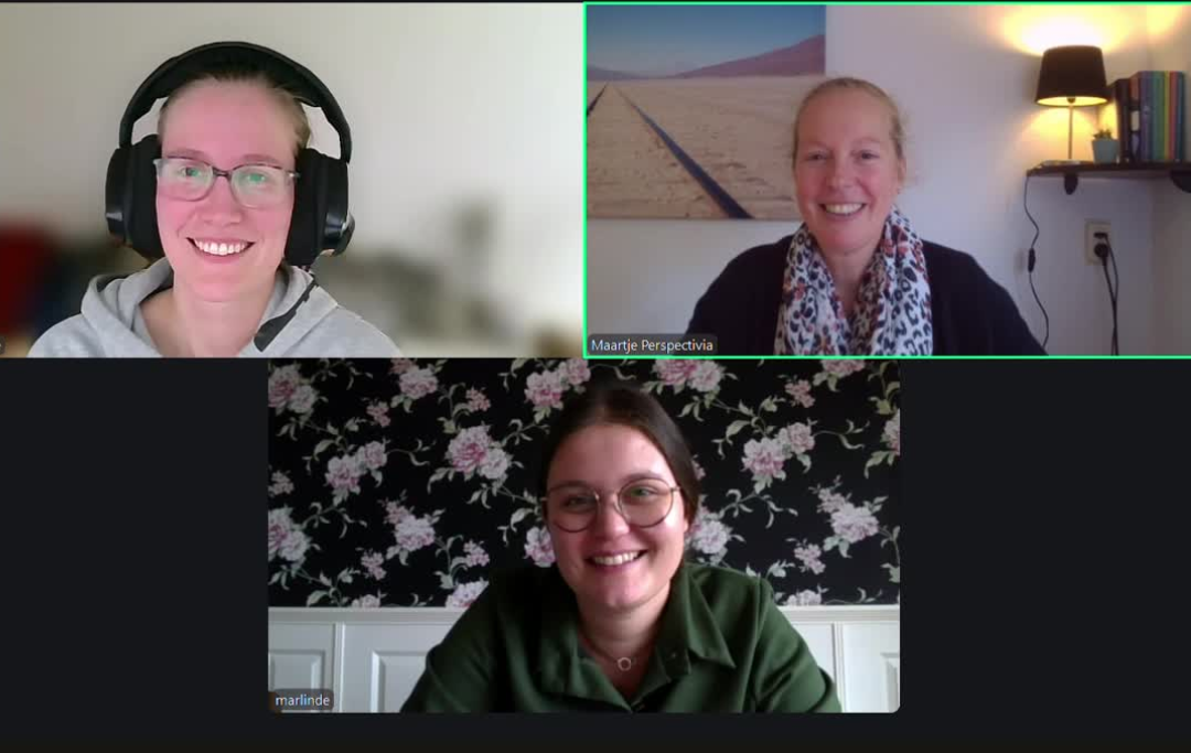 Drie mensen glimlachen tijdens een videogesprek, elk in een apart webcamvenster.