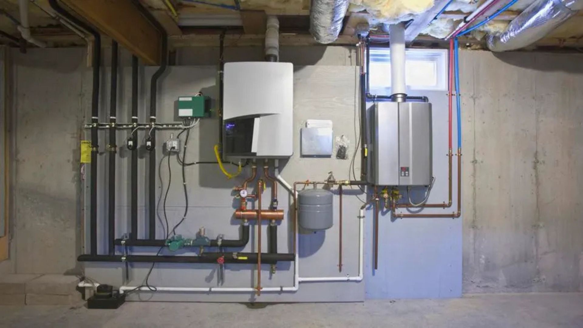A basement with a lot of pipes and a boiler on the wall.