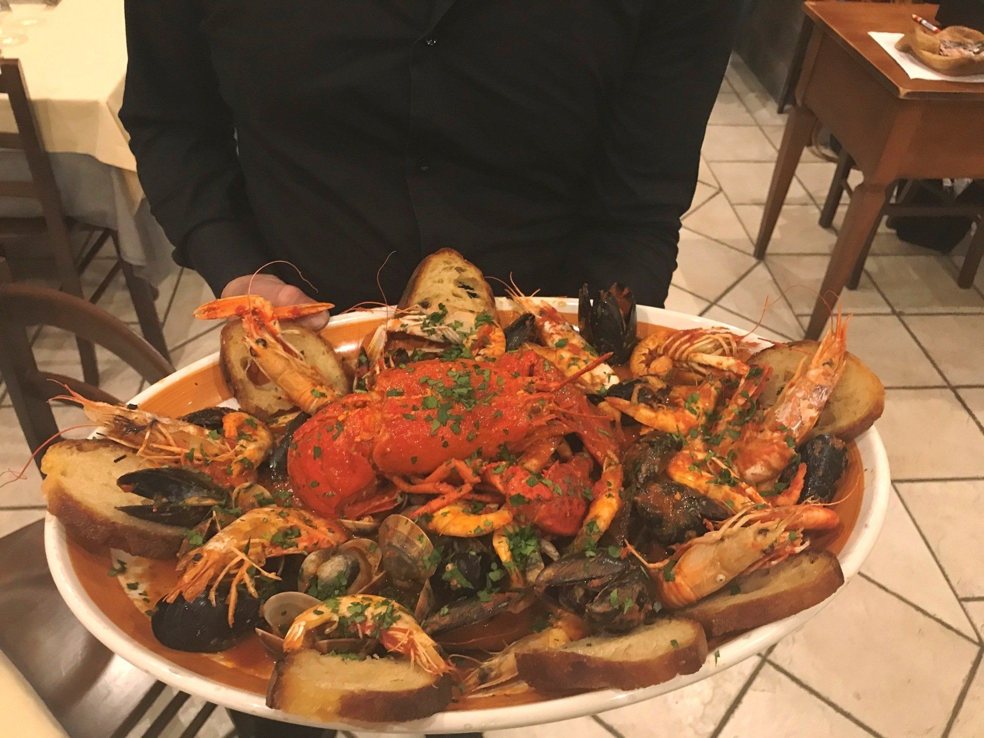 Una pentola piena di frutti di mare e verdure su un tavolo.
