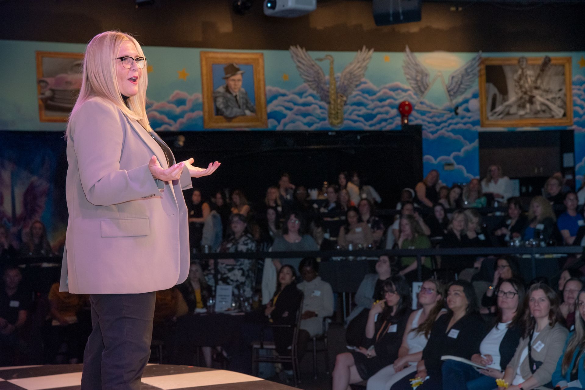 Woman giving a presentation to a group in a brightly lit room.