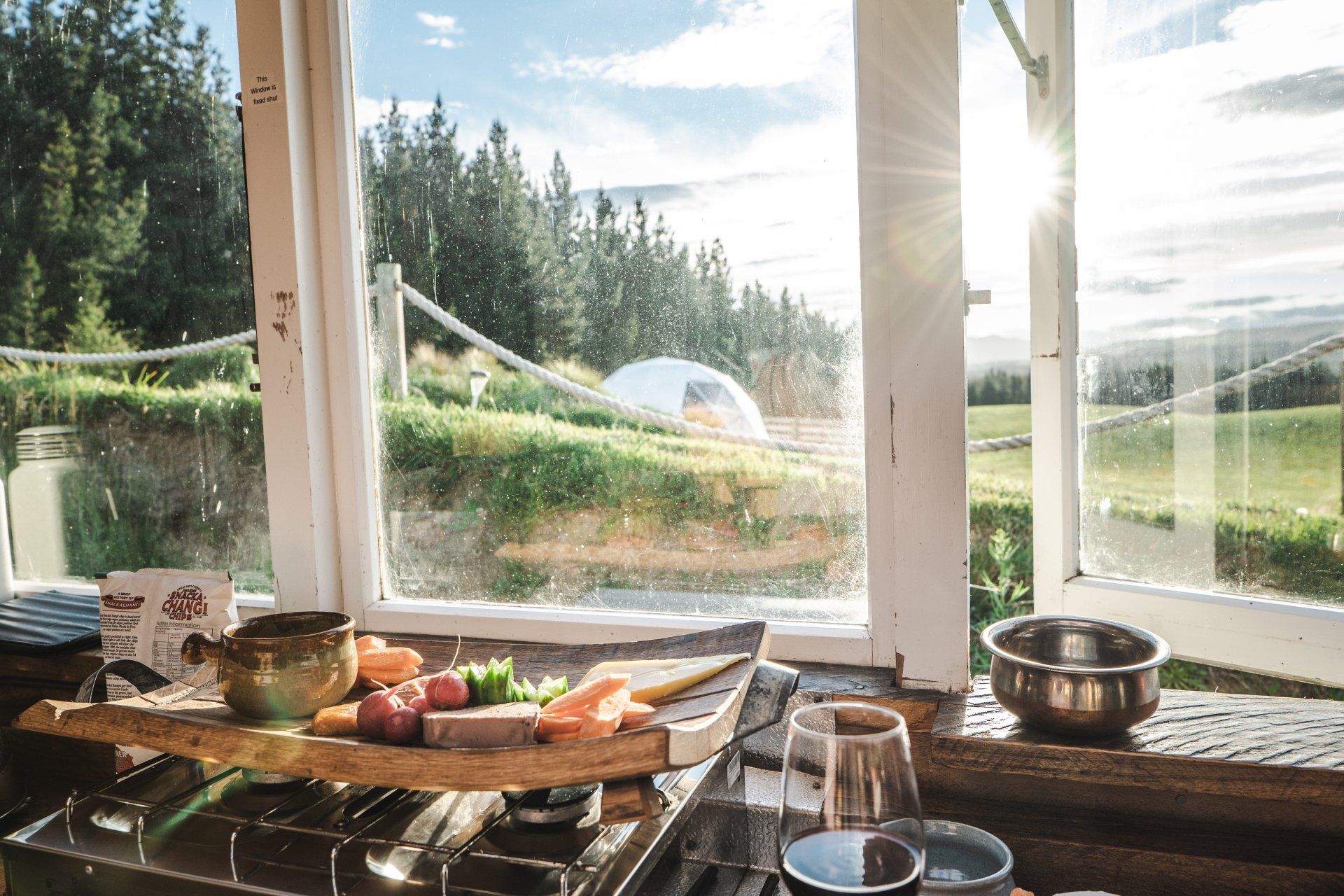 A window with a view of a field and trees