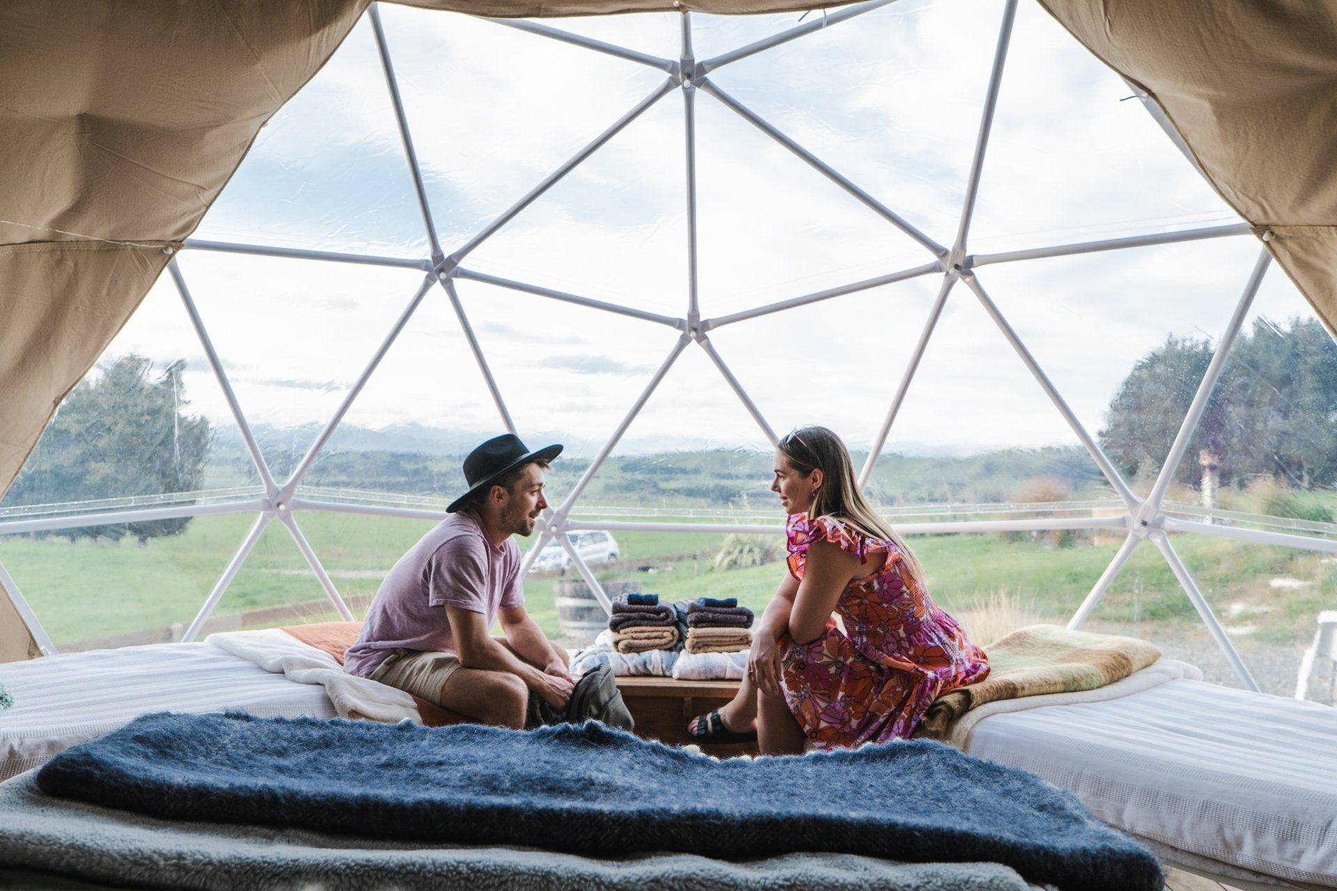 A man and a woman are sitting in a dome looking at each other.