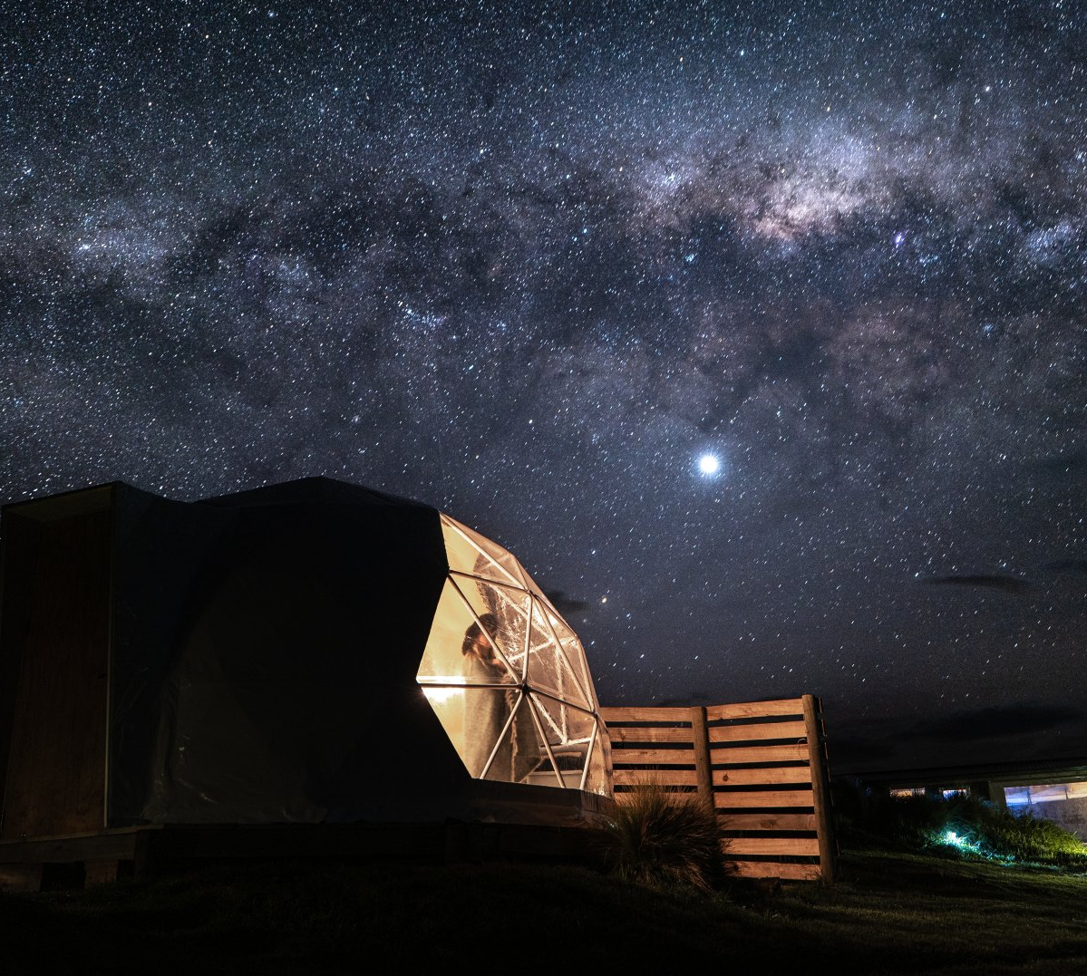 A starry night sky with a dome in the foreground