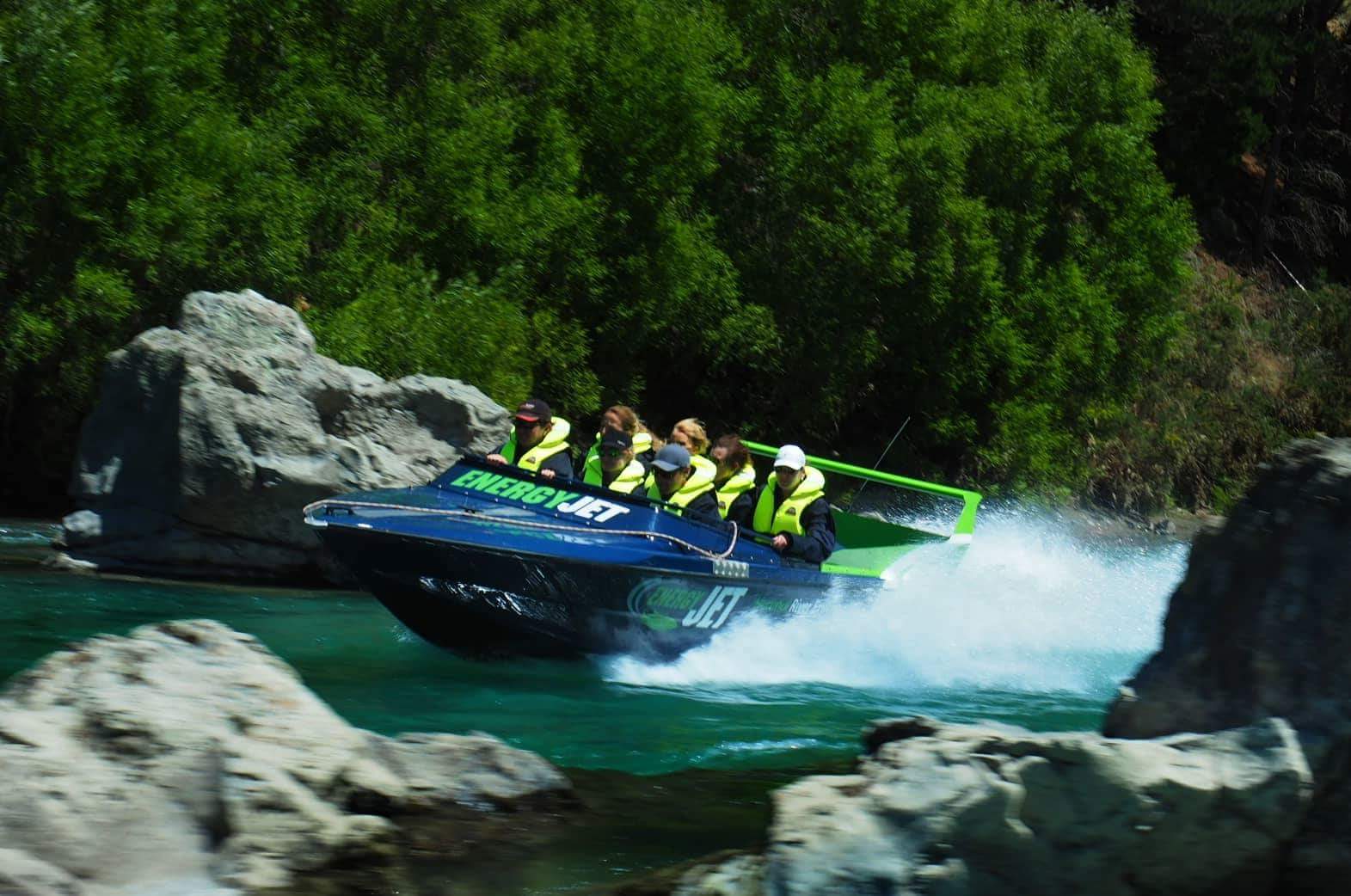 A group of people are riding a jet ski down a river