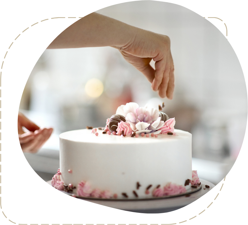 Una persona sta decorando una torta con fiori rosa