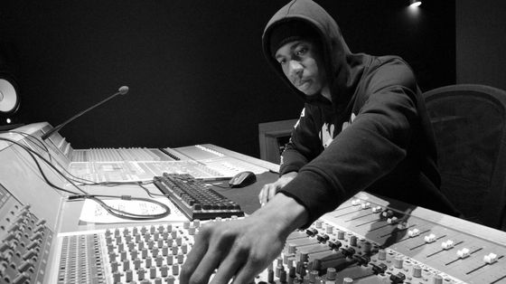 Alexander at sound mixing console, adjusting controls in a recording studio.