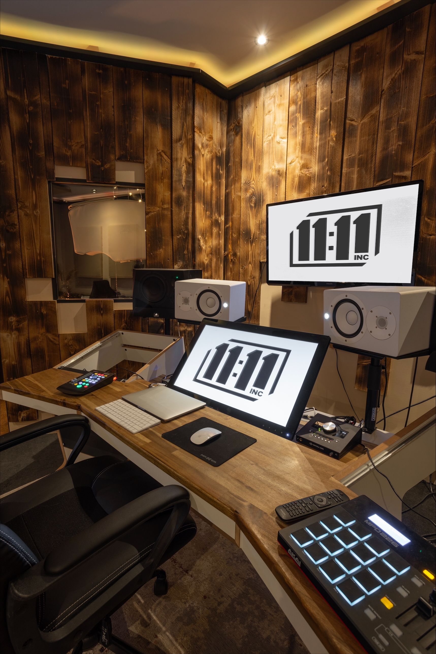 Recording studio with equipment, wood paneling, and digital displays featuring 