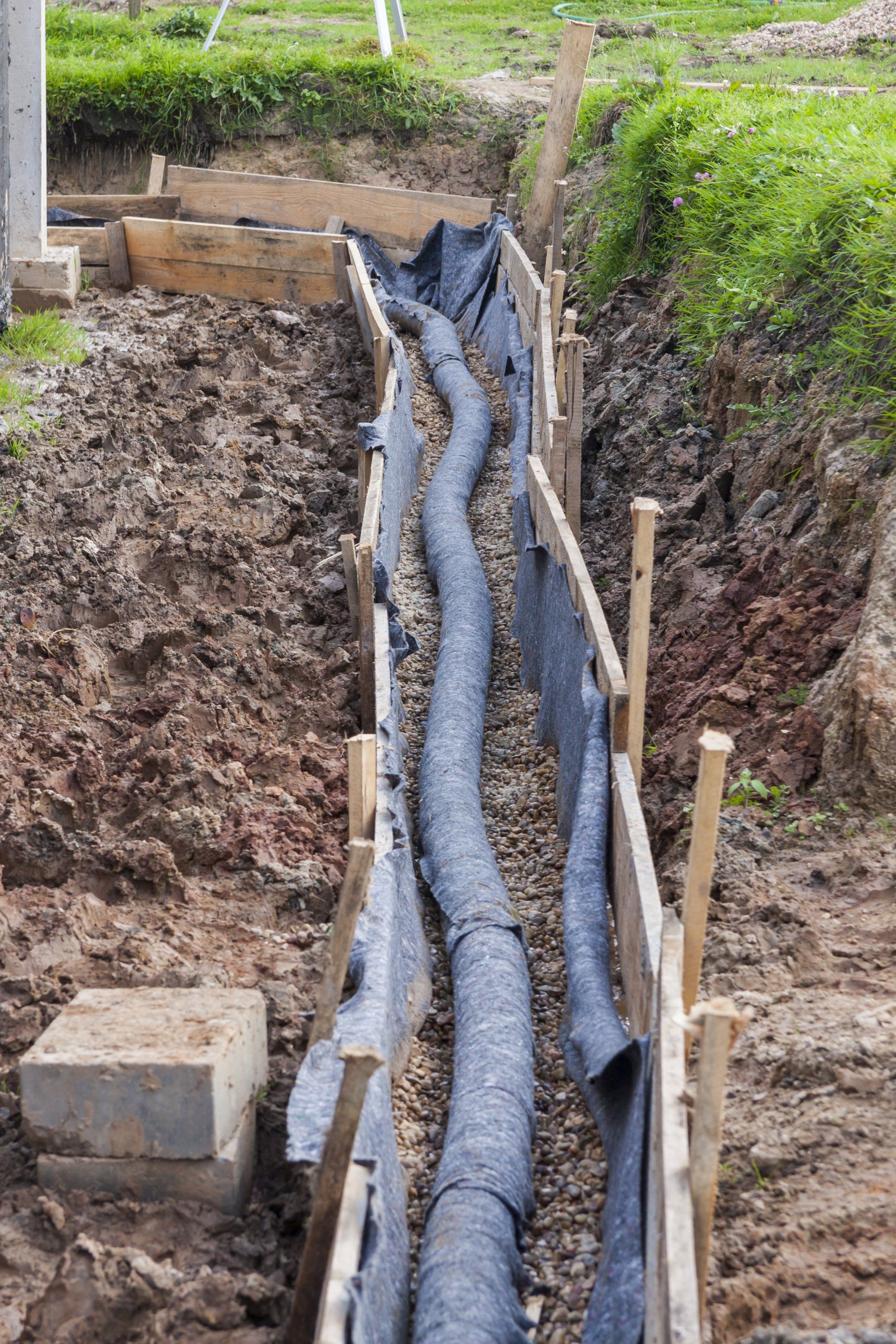 A large pipe is being installed in a trench.