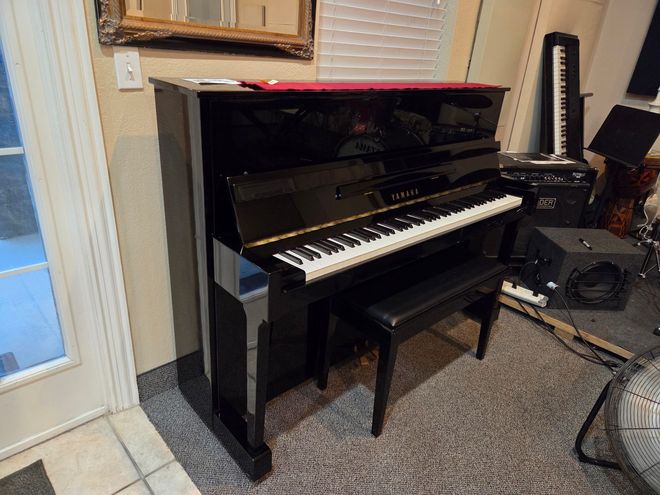 A person is playing a piano with their hands on the keys.
