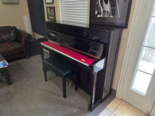 A piano is sitting on a stage next to a bench