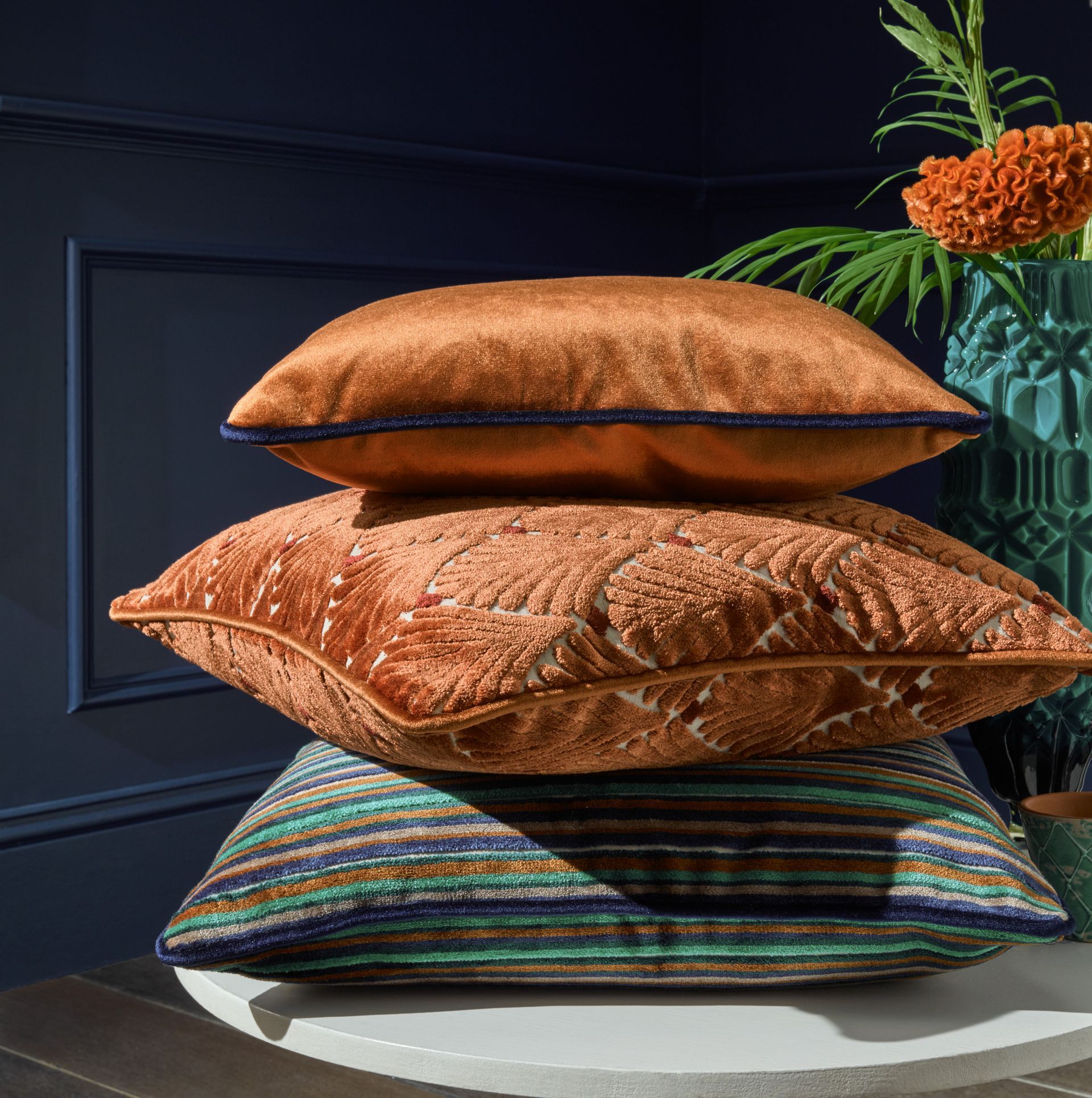 Three pillows are stacked on top of each other on a table.