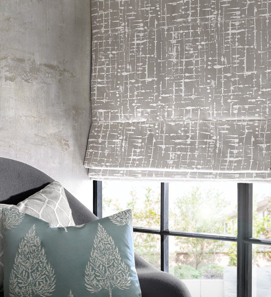 A chair with a pillow on it and a window with a blind on it
